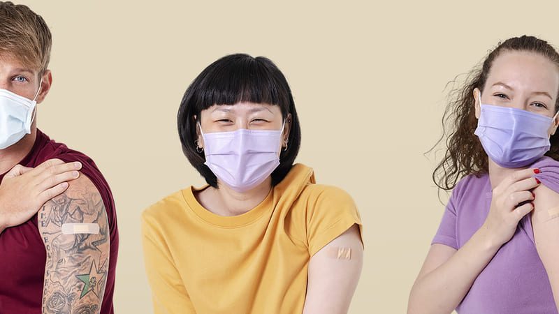 Grupo de cinco pessoas de diferentes perfis usando máscaras faciais e mostrando o braço com curativo após vacinação.