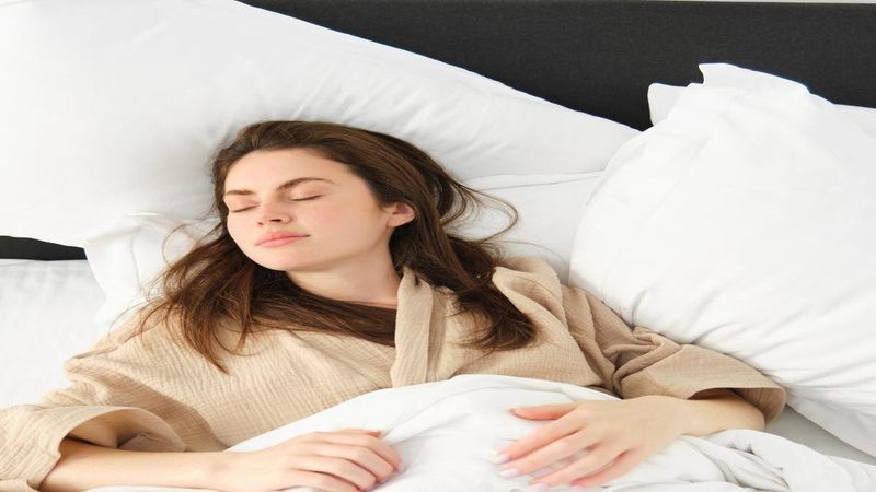 Mulher dormindo confortavelmente em sua própria cama, representando a realização do Exame do Sono domiciliar para diagnóstico de apneia do sono.